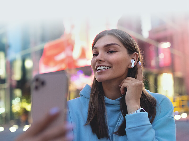 A girl wearing W200Tmini earbuds, talking with phone