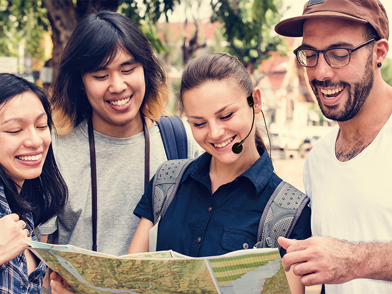 Four people looking at map, the girl wearing EDIFIER Portable Voice Amplifier